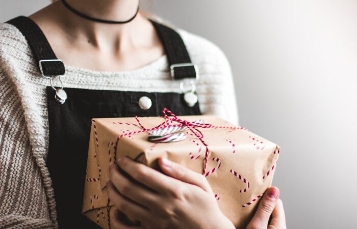 close up photography of woman holding grey and red box